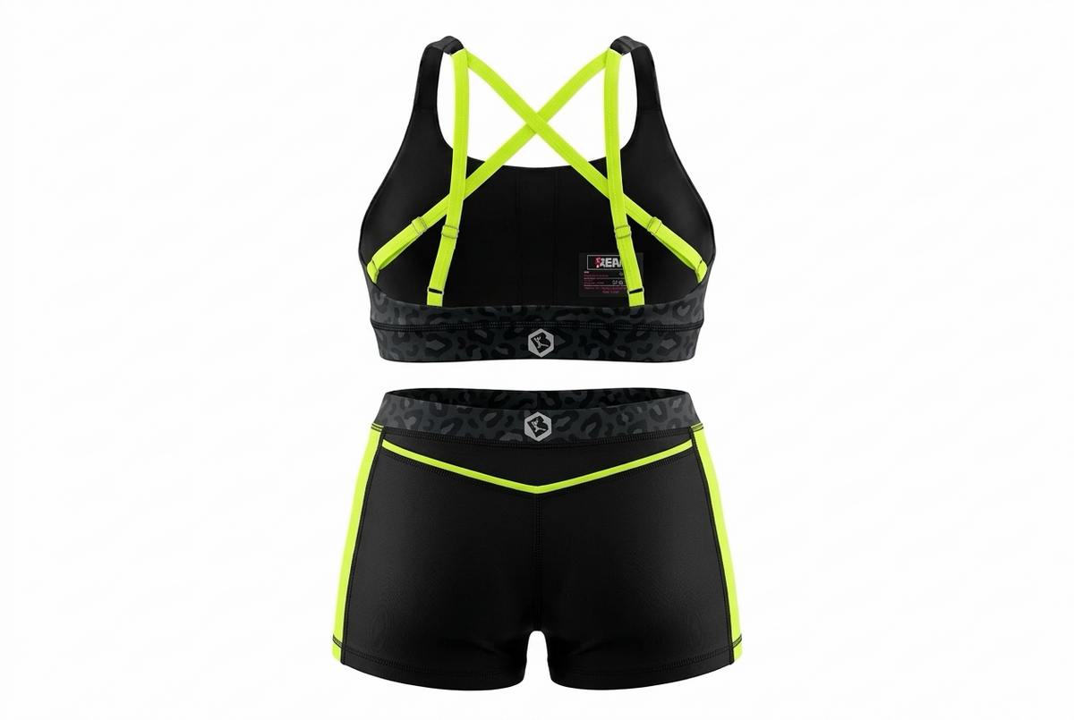 A two-piece athletic set consisting of a sports bra and matching shorts in black with bright neon yellow-green trim and straps, shown on a plain white background.