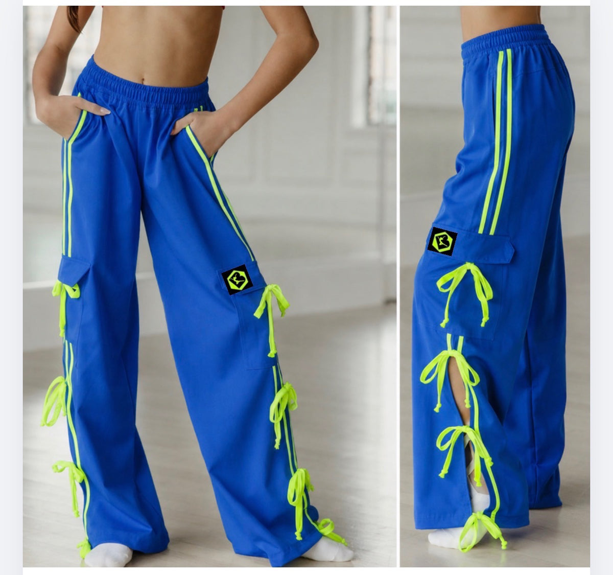 Blue wide-leg cargo pants with neon yellow-green side stripes, matching tie-front laces, and small hexagonal patch details, shown on a model from the front and side against a bright indoor background.