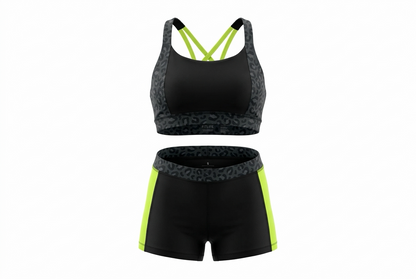 A two-piece athletic set featuring a black sports bra with neon yellow-green straps and patterned gray sides, paired with matching black shorts that have neon yellow-green side panels and a patterned gray waistband.